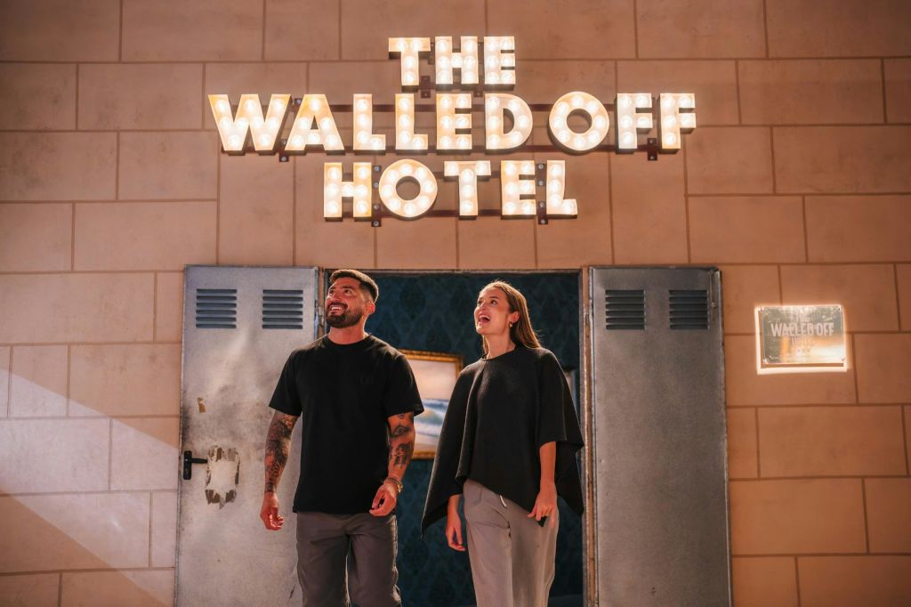 전시회에서 한 커플이 "The Walled Off" 호텔 레크리에이션을 종료합니다.