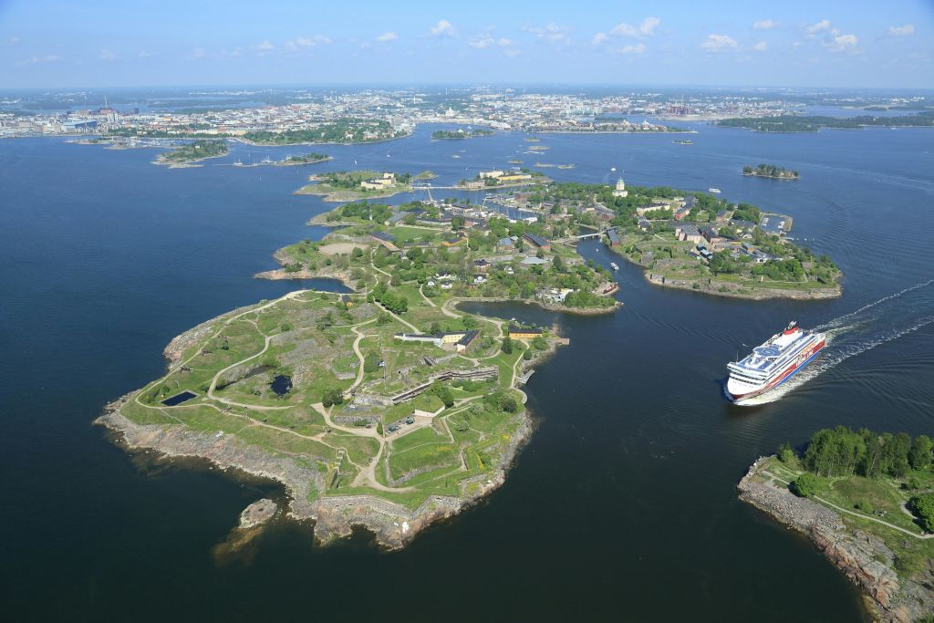 녹색 섬, 건물, 통로, 해안선 근처에 정박한 대형 유람선이 있는 군도의 공중 전망.