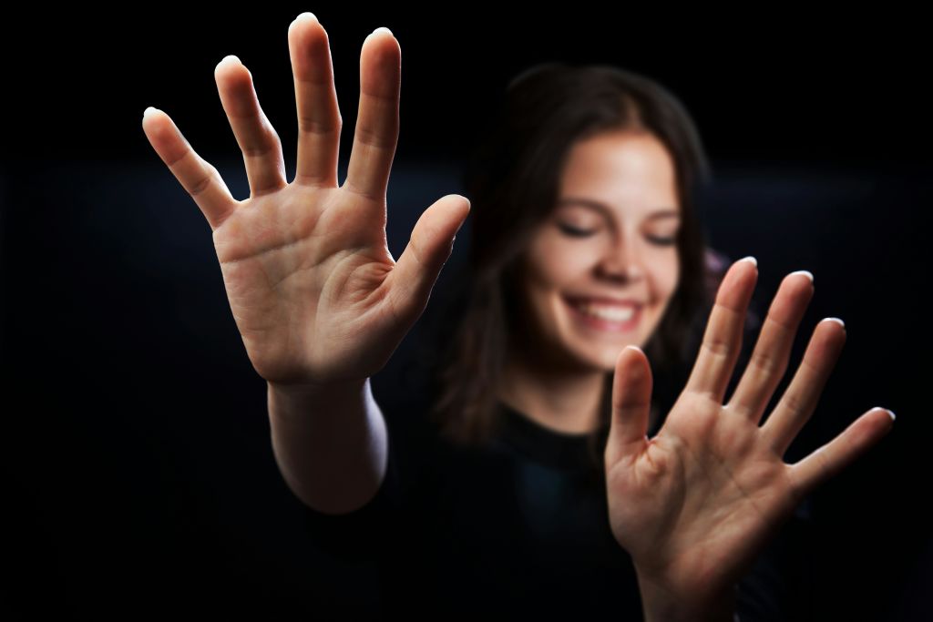 눈을 감은 여성이 손을 내밀고 있다.