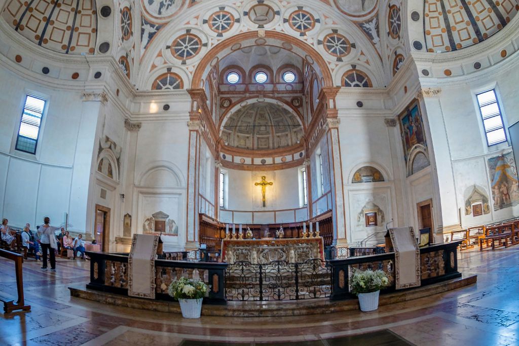 화려한 제단, 황금 십자가, 아치형 천장, 정교한 건축 디테일이 돋보이는 화려하게 장식된 교회 내부.