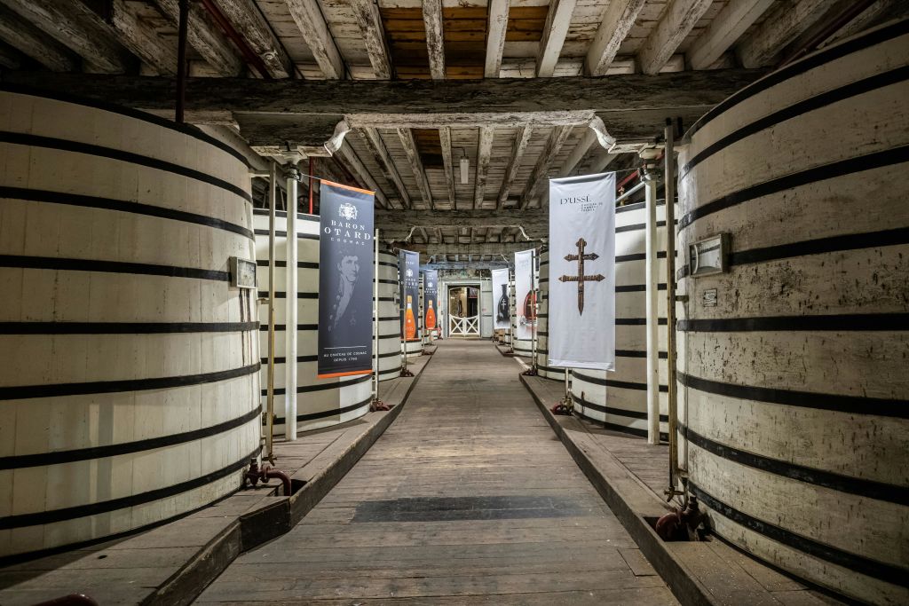 소박한 건물의 커다란 줄무늬 통 옆으로 목조 통로가 있으며, 현수막과 대들보가 있는 천장이 있습니다.