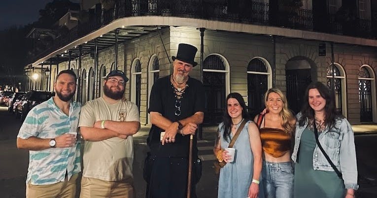 한 명은 모자를 쓰고 지팡이를 들고, 다른 한 명은 평상복을 입은 채 야간 도심에서 포즈를 취하는 사람들.