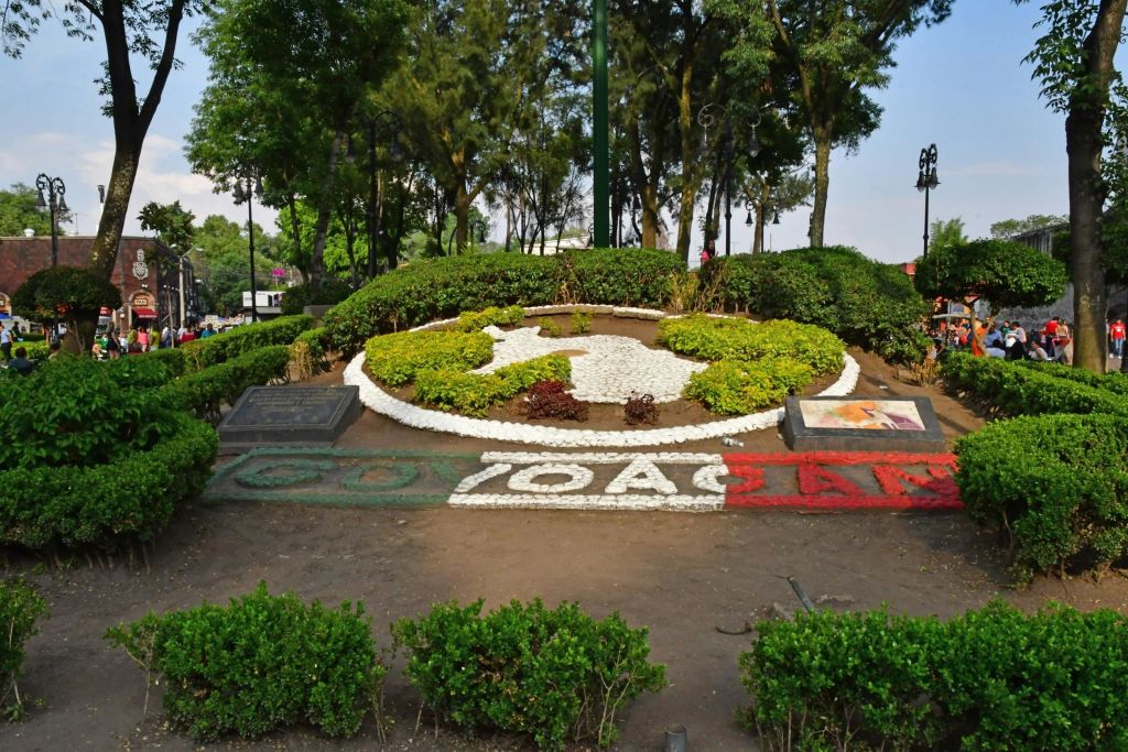 원형 디자인을 이루도록 식물을 배치한 조경 정원. "COYOACÁN" 은 전면에 형형색색의 바위로 철자가 새겨져 있습니다.