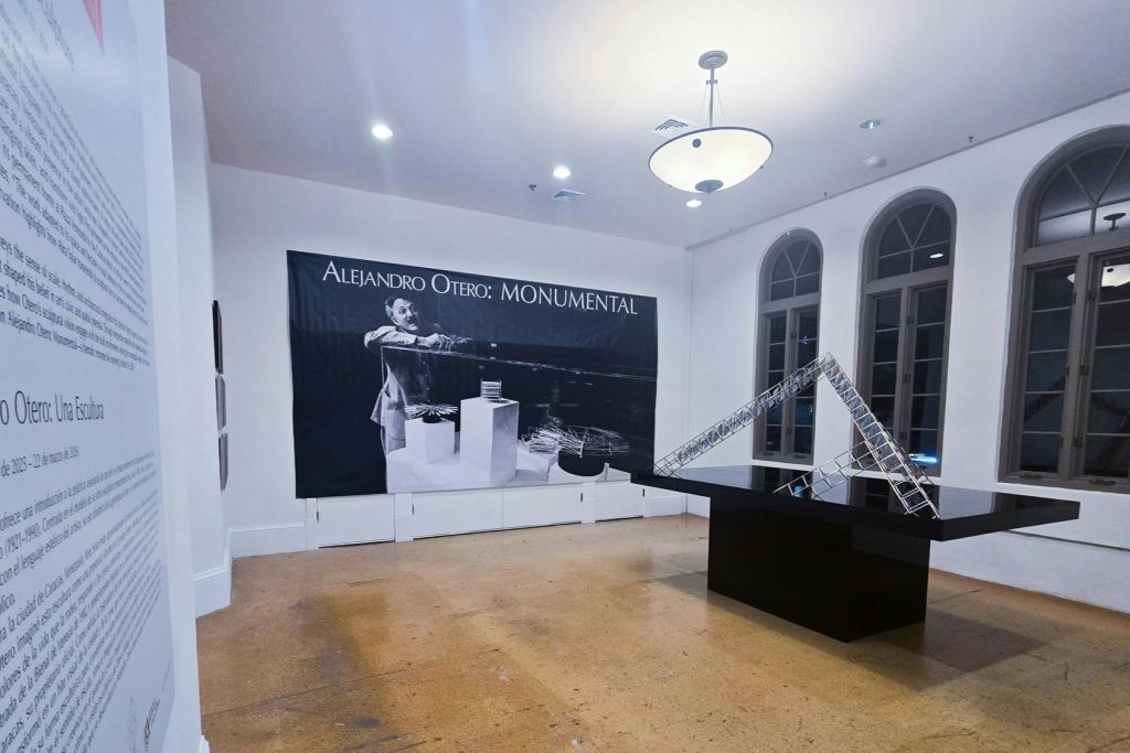 'Alejandro Otero: Monumental' 이라는 제목의 전시물을 전시하는 갤러리 공간으로, 대형 배너와 현대적인 조각품이 전시되어 있습니다.