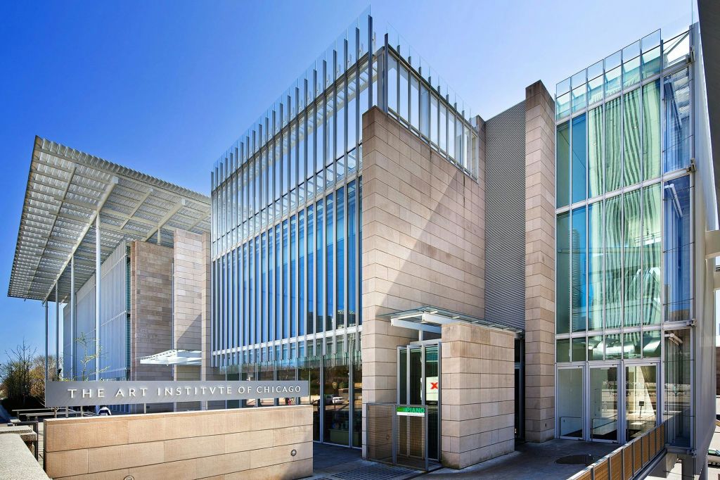 맑고 푸른 하늘 아래 "시카고 아트 인스티튜트" 를 나타내는 표지판이 있는 현대적인 유리 및 석조 건물 외관.