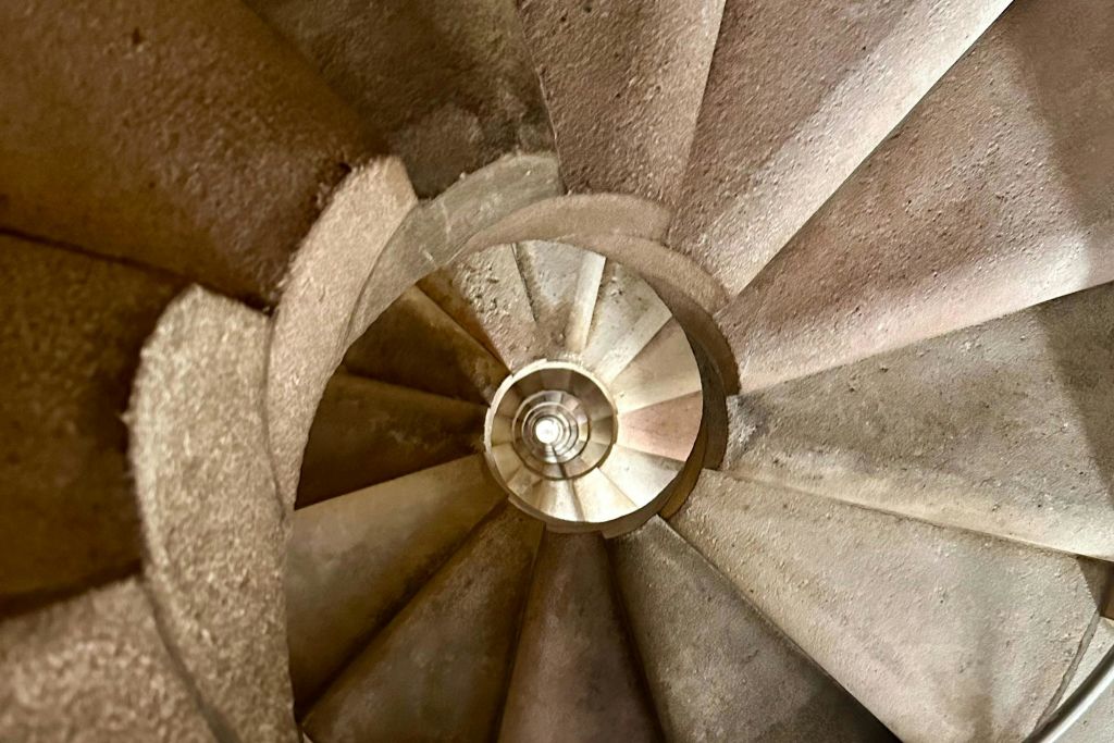 돌계단과 중앙 원형 개구부가 있는 나선형 계단을 내려다보세요.