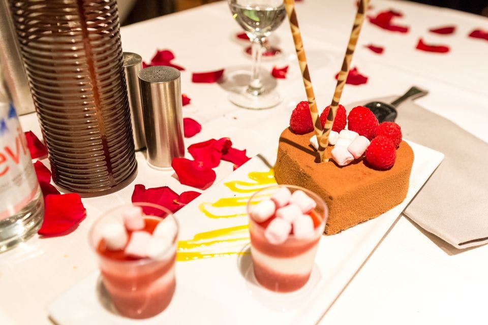 디저트는 테이블 위에 장미 꽃잎으로 장식된 초콜릿 케이크, 라즈베리, 마시멜로, 층층이 쌓인 무스 컵으로 퍼집니다.