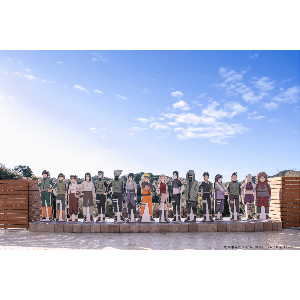 부분적으로 흐린 하늘 아래 플랫폼에 표시된 애니메이션 "나루토" 의 다양한 캐릭터의 판지 컷아웃.