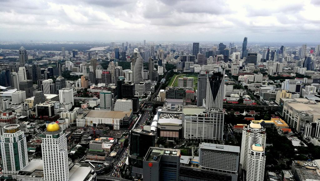 흐린 하늘 아래 수많은 고층 빌딩, 건물, 도로가 밀집한 도시 풍경을 공중에서 감상할 수 있습니다.