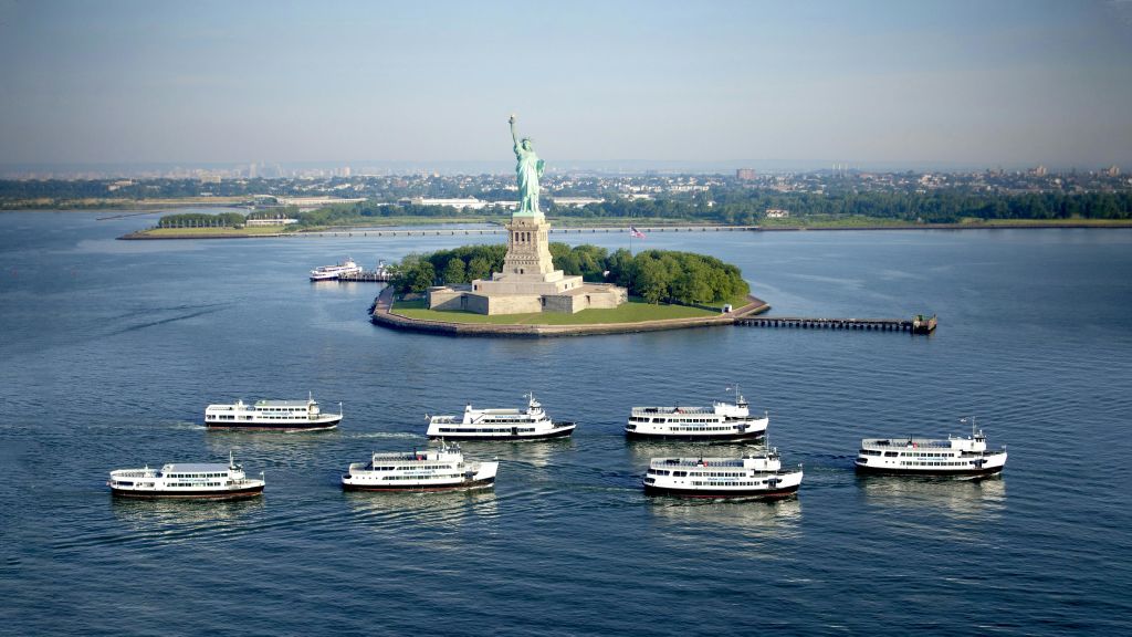 맑은 날 주변에 여러 개의 페리가 있는 리버티 섬의 자유의 여신상.