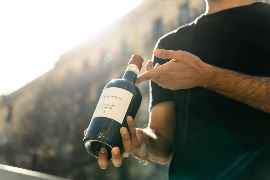 레드 와인 한 병을 들고 있는 남자.