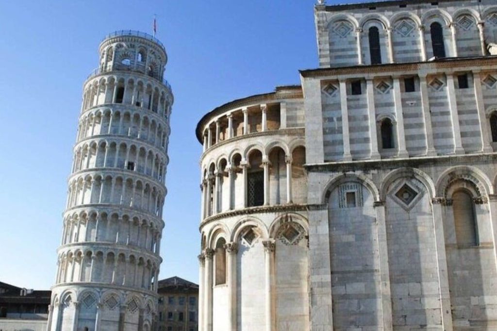 피사의 사탑과 맑고 푸른 하늘 아래 로마네스크 건축물이 있는 인접한 건물.