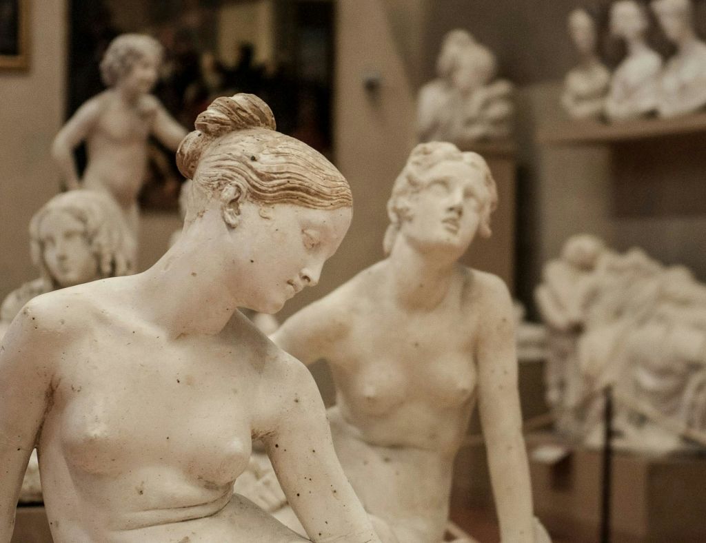 다양한 포즈의 여성 대리석 조각상 여러 개가 박물관 갤러리에 전시되어 있습니다.
