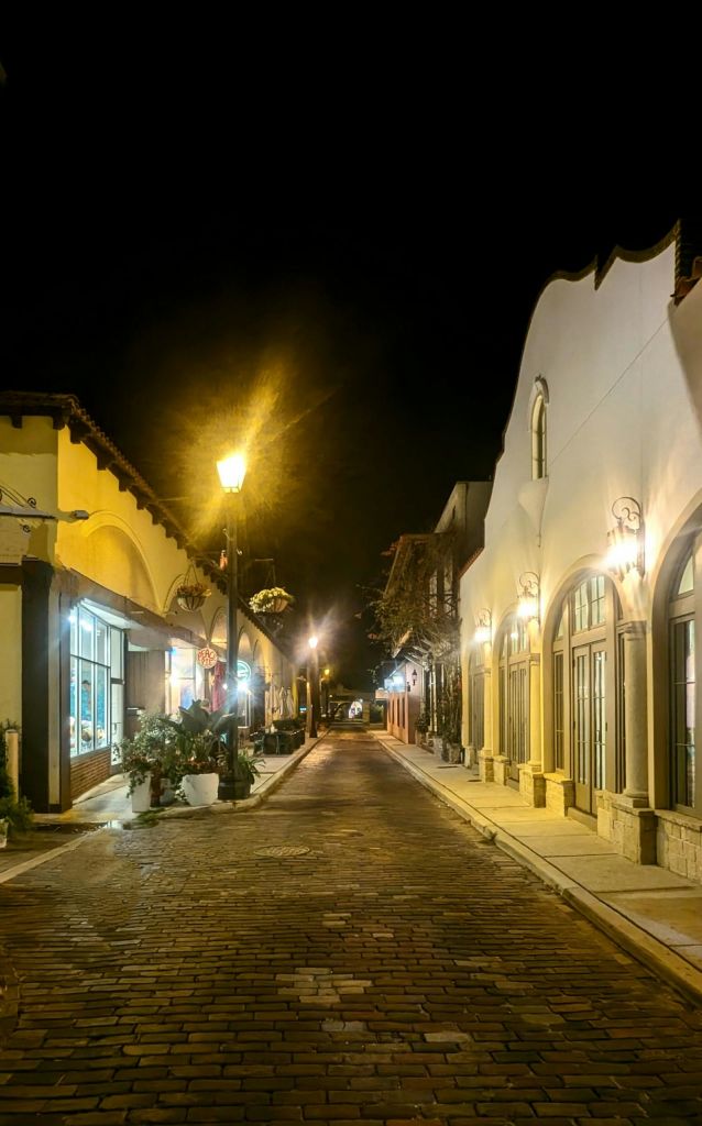 야간에는 조명이 켜진 상점가와 아치형 창문이 늘어선 자갈길이 가로등으로 비춰집니다.