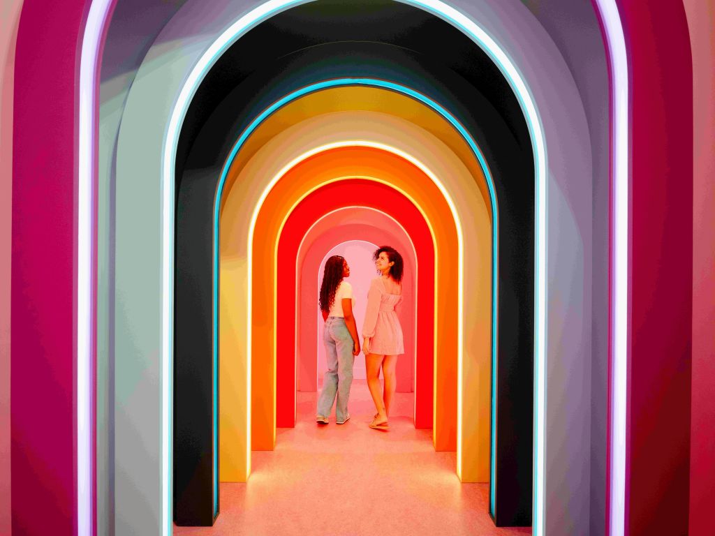 복도의 화려하고 빛나는 아치 아래 서서 마주보고 있는 두 사람.