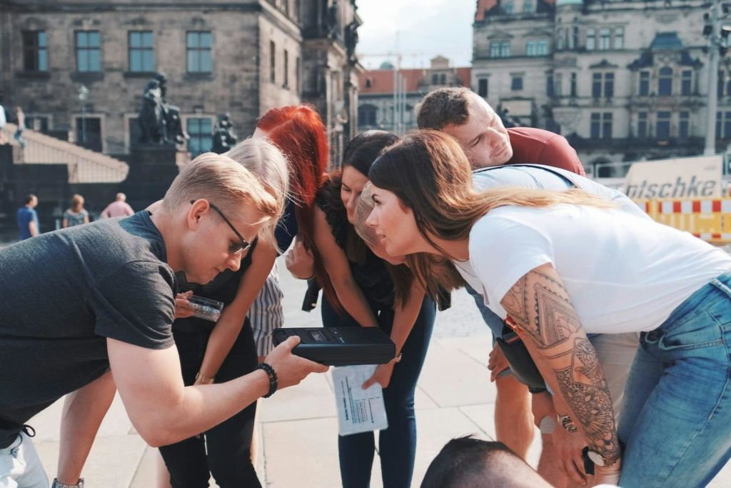 에픽 이스케이프의 아웃도어 이스케이프 게임에서 퍼즐을 풀고 있는 친구들.