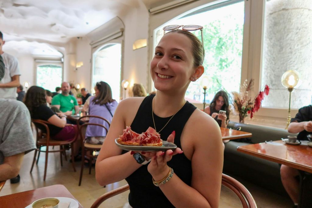 미소 짓는 게스트가 시식 체험 중 구운 빵에 자몬 이베리코 한 접시를 자랑스럽게 선물합니다.