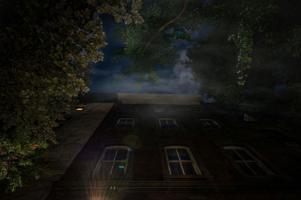 머리 위로 으스스한 구름이 드리워진 뉴욕 죽음의 집의 야간 사진