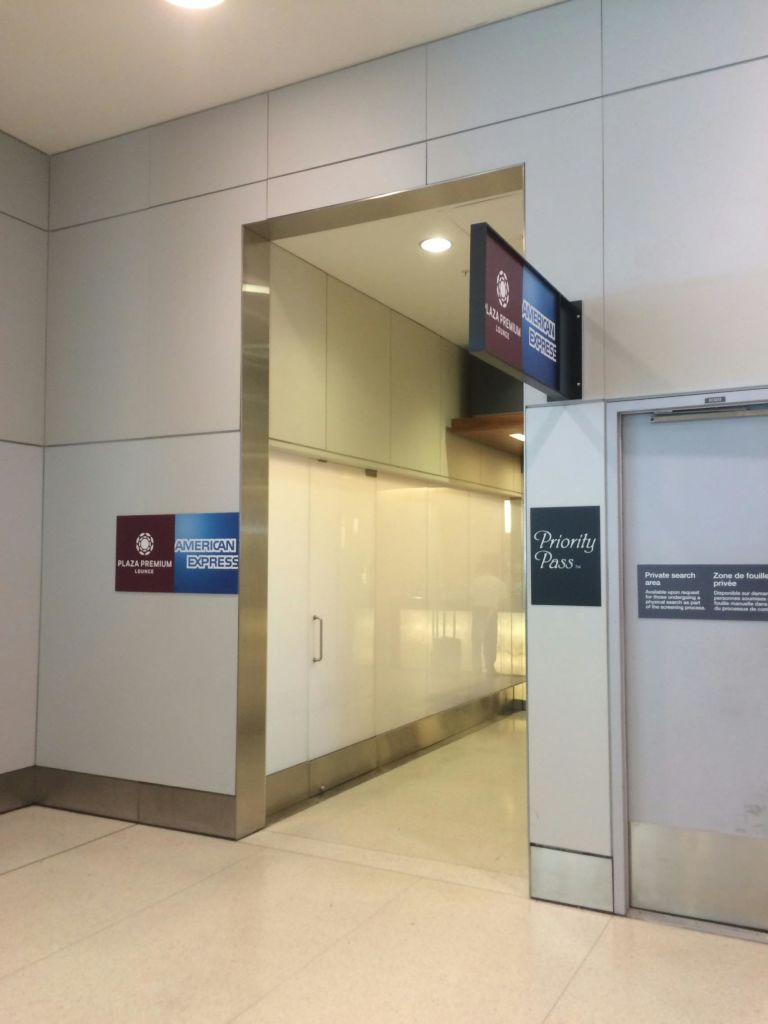 Plaza Premium, American Express, Priority Pass 이용 안내 표지판이 있는 공항 라운지 입장.
