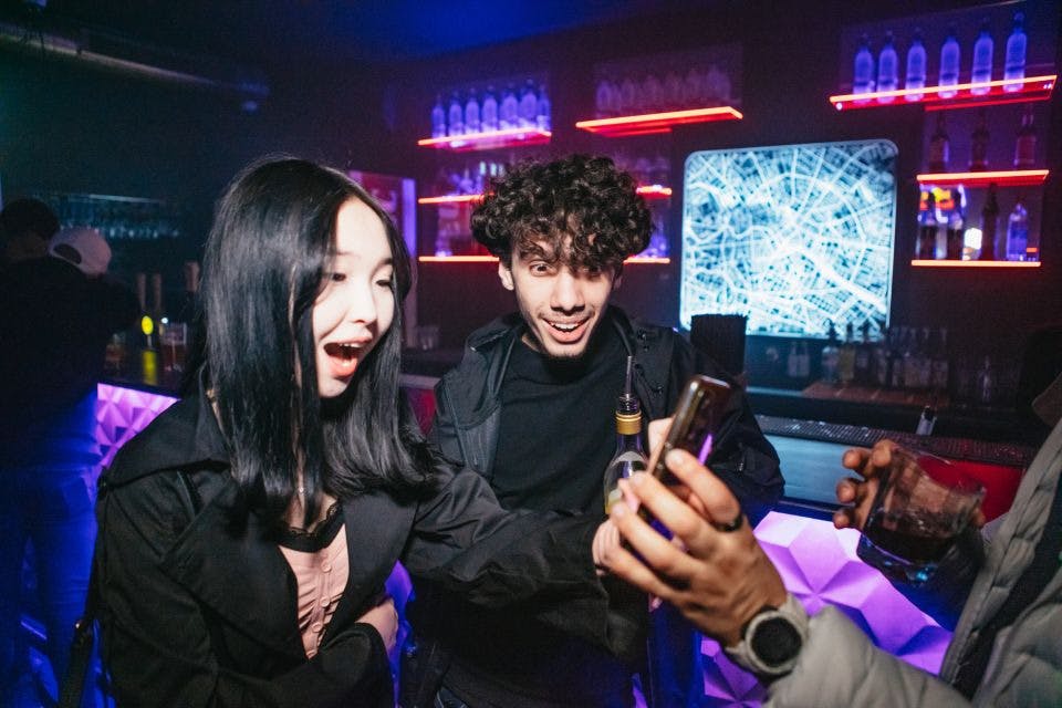 휴대전화 화면을 보고 깜짝 놀란 소녀와 한 남자