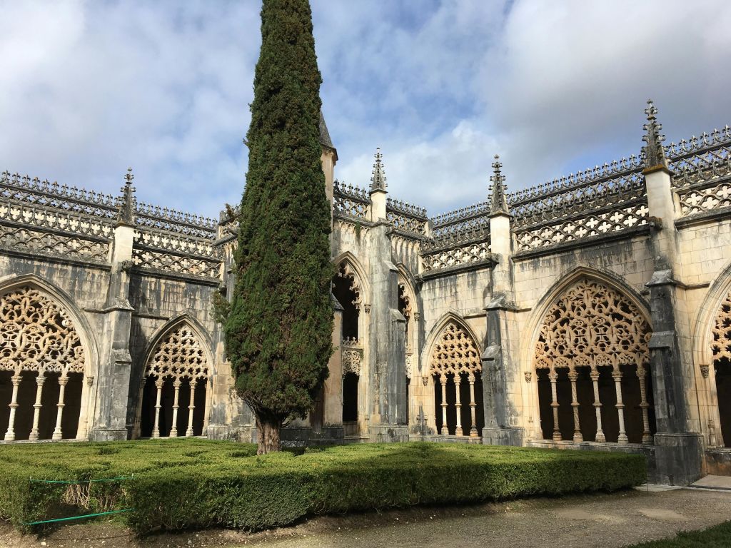 정교한 고딕 양식의 아치와 첨탑이 있는 역사적인 건물로 높고 울창한 나무와 잘 다듬어진 울타리가 있는 안뜰이 특징입니다.