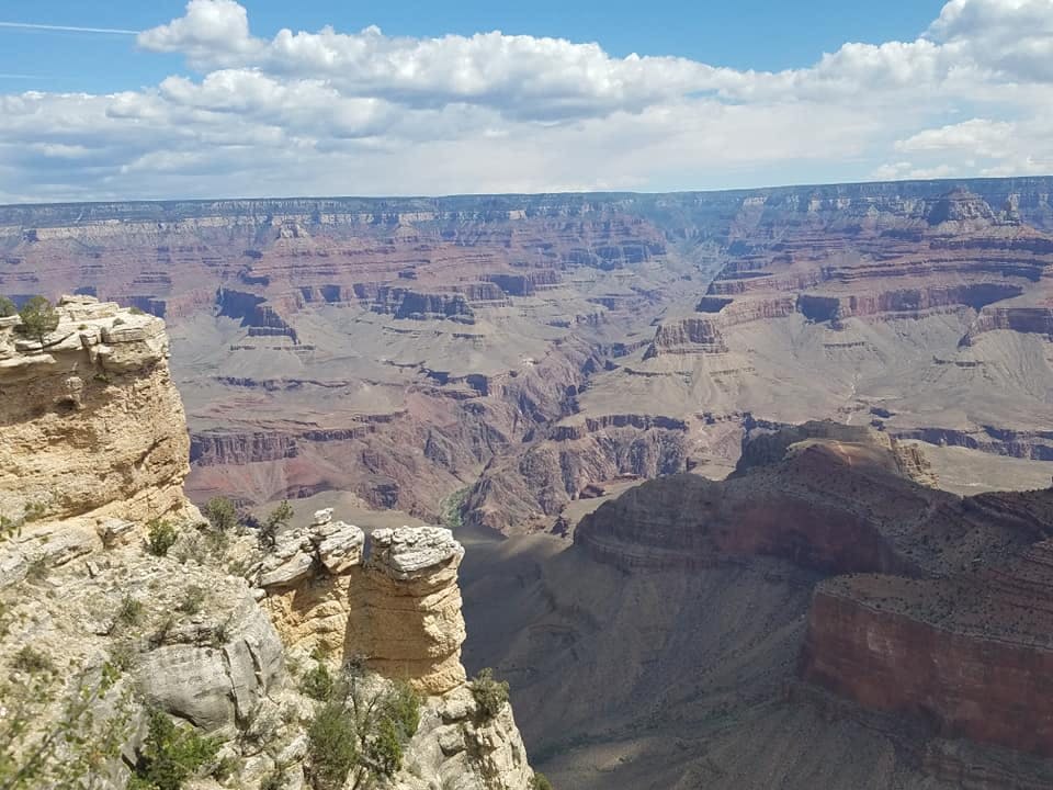 겹겹이 쌓인 암석층과 깊은 계곡, 흐리고 푸른 하늘을 배경으로 그랜드캐니언의 절경을 감상할 수 있습니다.