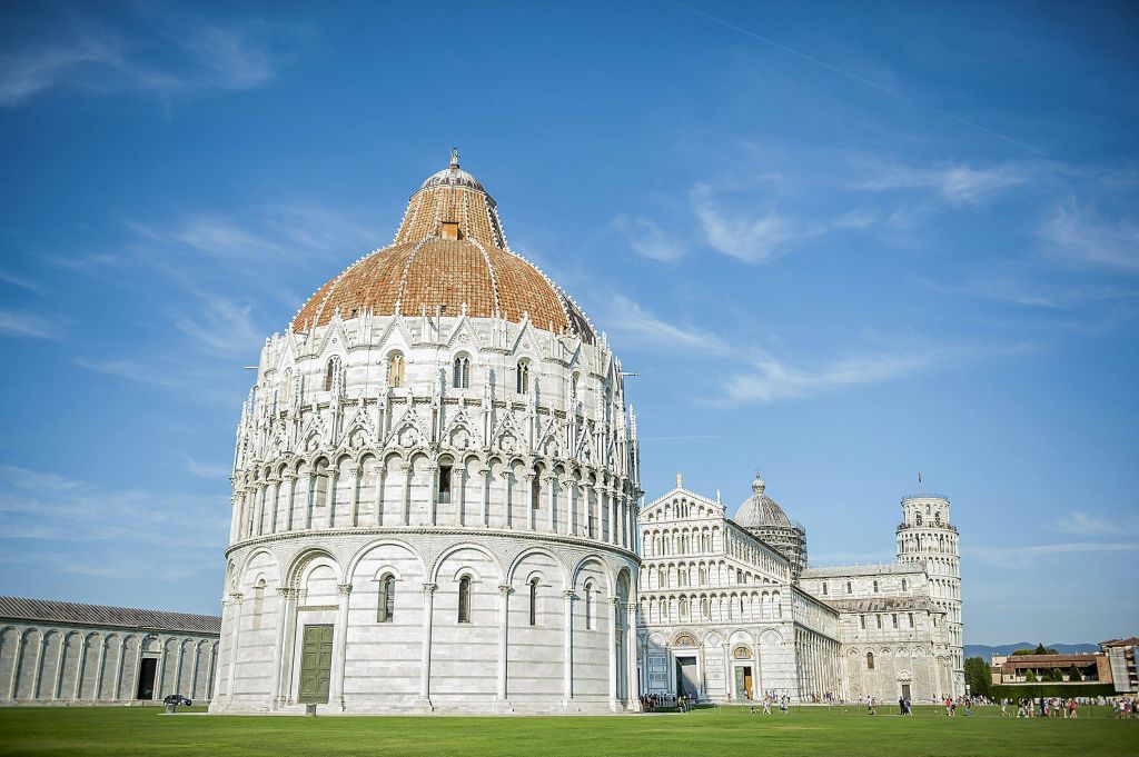 맑고 푸른 하늘 아래 성당 단지의 일부인 돔형 지붕이 있는 흰색 대리석 세례당.