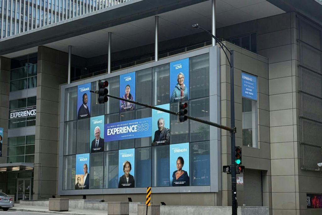 "Experience 360" 이라는 제목의 전시 포스터를 전시하는 건물 외관으로, 초상화와 영감을 주는 문구가 있습니다.