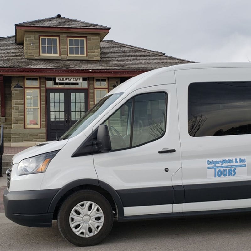 '철도 카페' 라고 적힌 유서 깊은 건물 앞에 흰색 밴이 주차되어 있습니다.