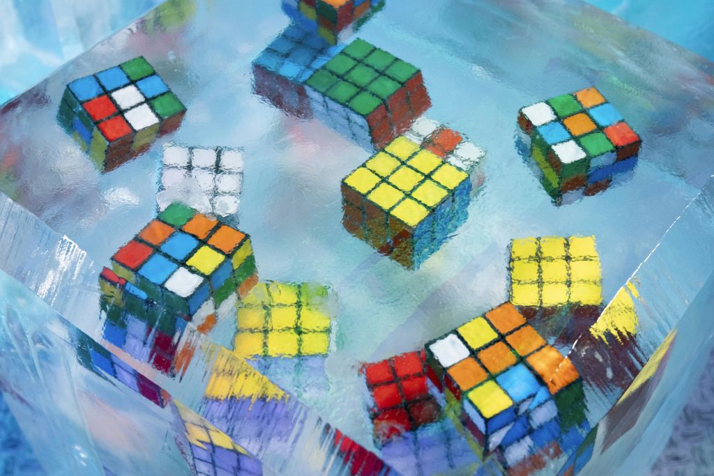 루빅스 큐브는 파란색의 얼음 같은 반투명 소재로 장식되어 다채롭고 다양한 색상의 면을 보여줍니다.