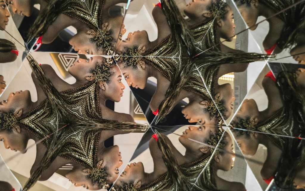 머리카락이 땋아진 사람의 만화경 이미지로, 머리와 어깨가 여러 번 반사된 모습을 보여줍니다.