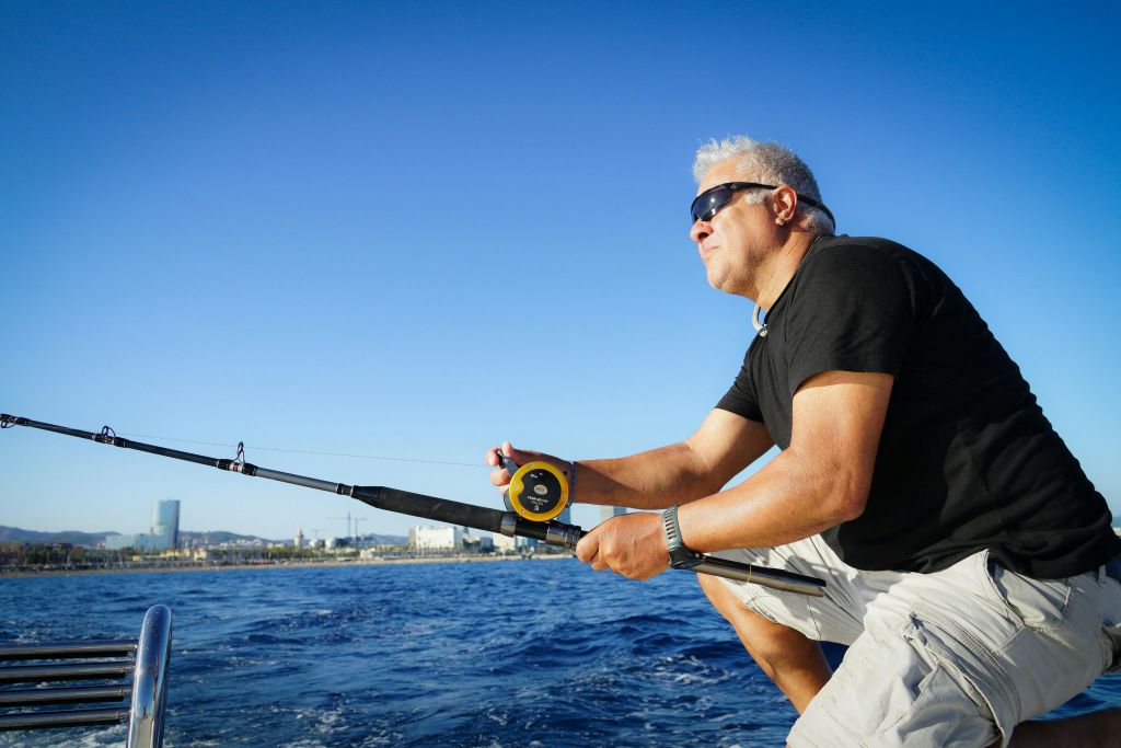한 남자가 수평선을 바라보며 낚싯대를 들고 있습니다.