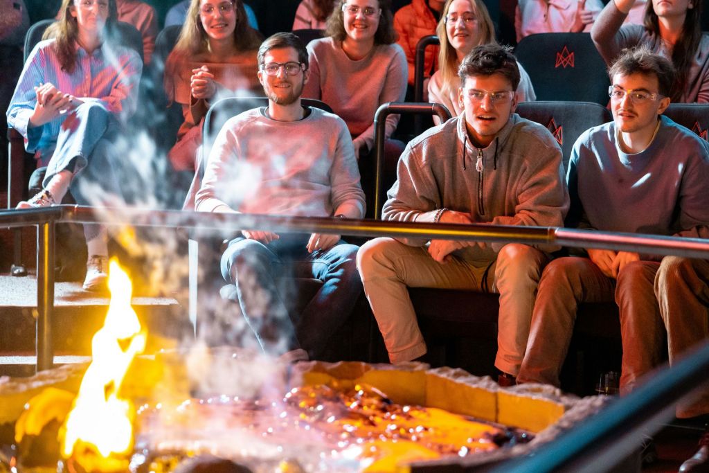 한 무리의 사람들이 라바 쇼에서 하얀 뜨거운 용암을 지켜보고 있습니다.