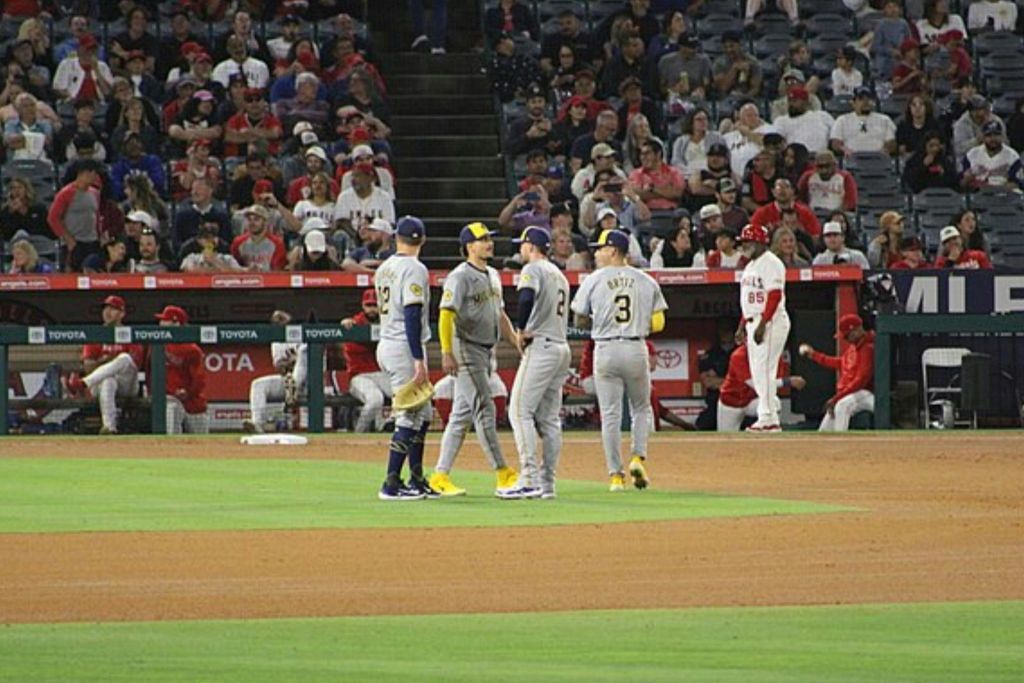 경기장에서 야구 선수들이 경기 중 팬들을 배경으로 앉아 있습니다.