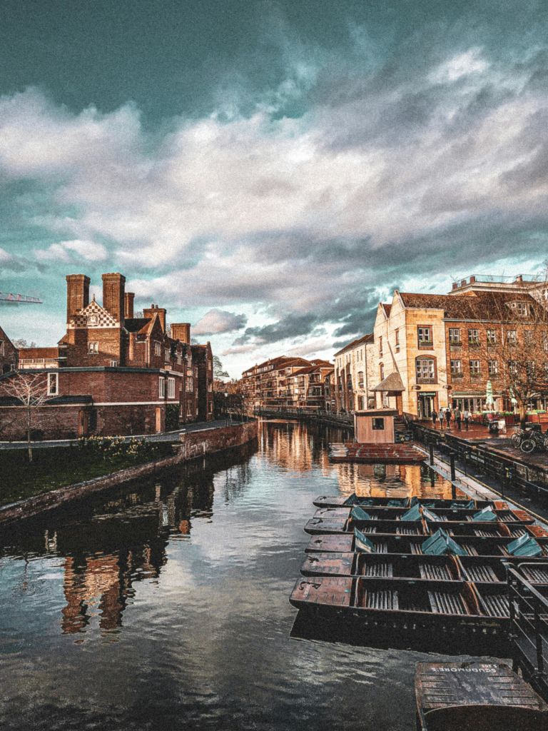 흐린 하늘 아래 양쪽에 유서 깊은 건물이 있는 운하에 배가 늘어서 있습니다.