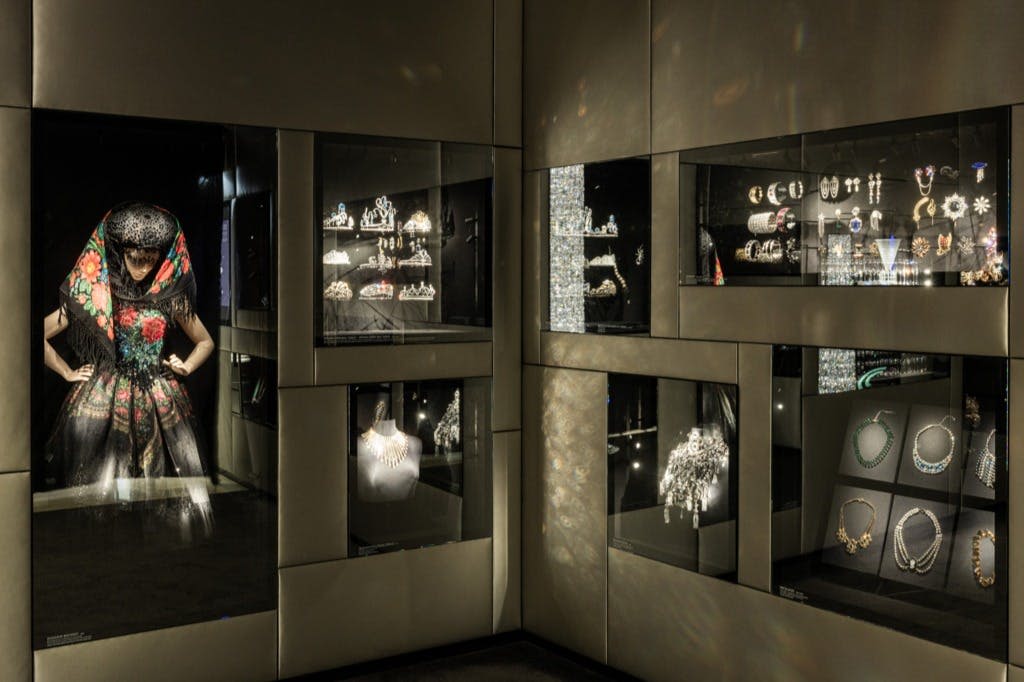 박물관과 같은 분위기에서 주얼리와 액세서리를 가볍게 감상할 수 있습니다. 컬러풀한 스카프를 두른 마네킹.