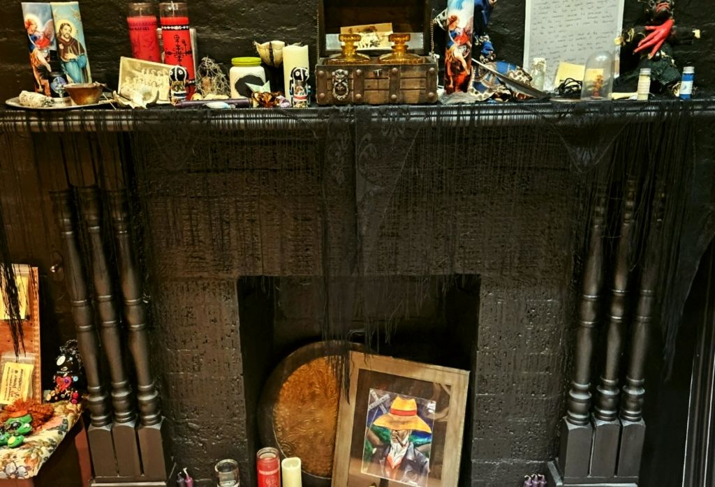 다양한 사물, 양초, 액자 그림 등 다양한 물건들이 놓여 있는 장식용 맨텔피스입니다.