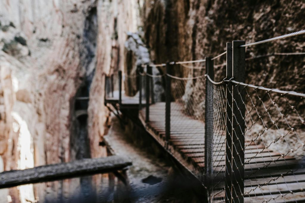 바위 협곡을 따라 난간이 매달려 있는 좁은 나무 산책로.