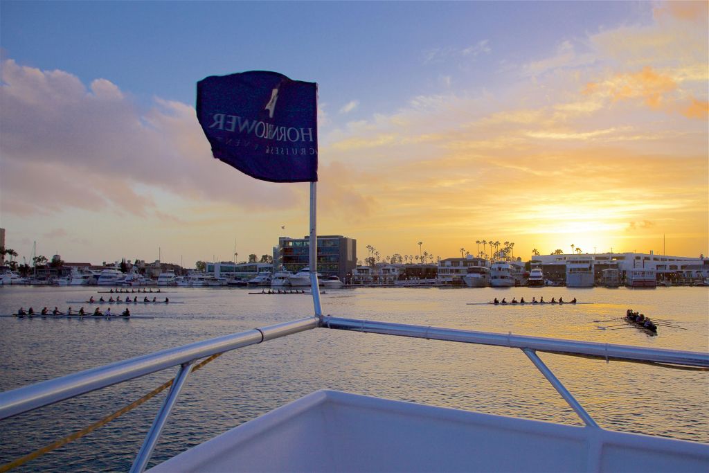 혼블로어 크루즈 (Hornblower Cruises) 깃발이 달린 보트에서 바라본 석양의 정박지를 바라보며 노를 젓는 팀과 함께 물속에서 바라보는 풍경.