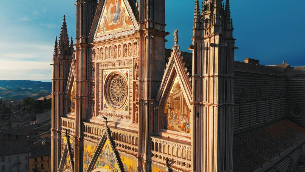 화려한 장식, 스테인드글라스 창문, 종교적 장면을 묘사한 세부 모자이크가 있는 고딕 양식의 성당 외관.