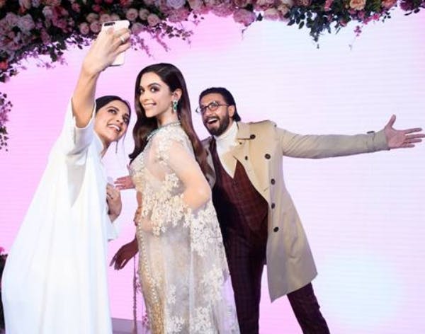 회색 양복을 입은 남자의 동상이 대리석 카운터 옆에 놓여 있으며, 그 뒤에는 선반에 물품이 놓여 있습니다. "ON THE RO" 텍스트가 표시됩니다.