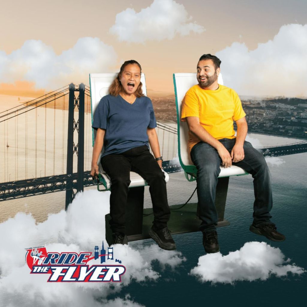 두 사람이 구름 위의 라이드 체어에 앉아 있으며, 도시와 다리를 배경으로 하고 있습니다. 텍스트에는 "전단지 타기" 라고 쓰여 있습니다.