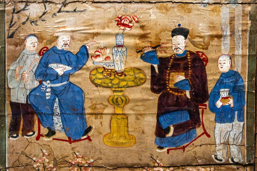 화려한 색상의 옷을 입은 두 인물, 꽃 장식이 있는 테이블, 세부 장면의 꽃병을 보여주는 전통 그림입니다.