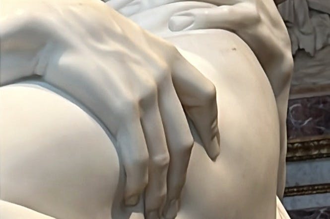 둥근 표면에 손을 얹은 모습을 그린 대리석 조각의 클로즈업으로 디테일한 조각을 선보입니다.