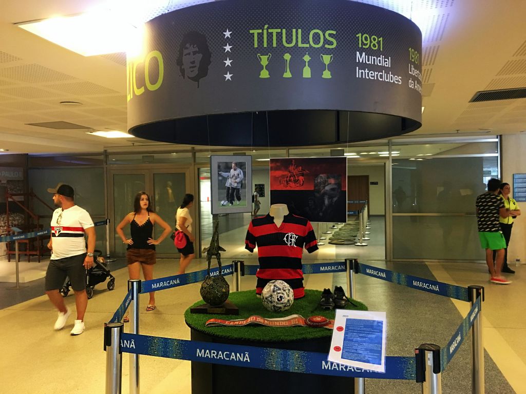 박물관에는 빨간색과 검은색 줄무늬 스포츠 저지, 축구 기념품, 안내 표지판이 있는 마네킹이 전시되어 있습니다.