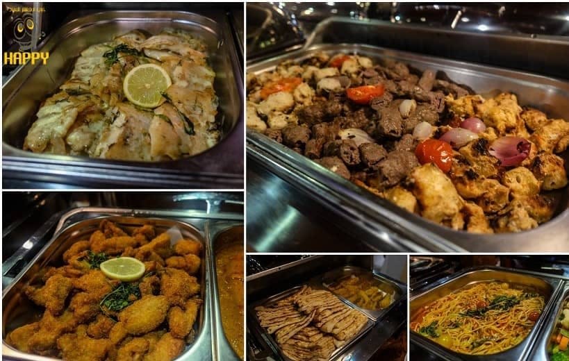 구운 야채, 레몬을 곁들인 생선 튀김, 구운 고기, 납작한 빵, 파스타가 담긴 다양한 뷔페 쟁반을 클로즈업합니다.