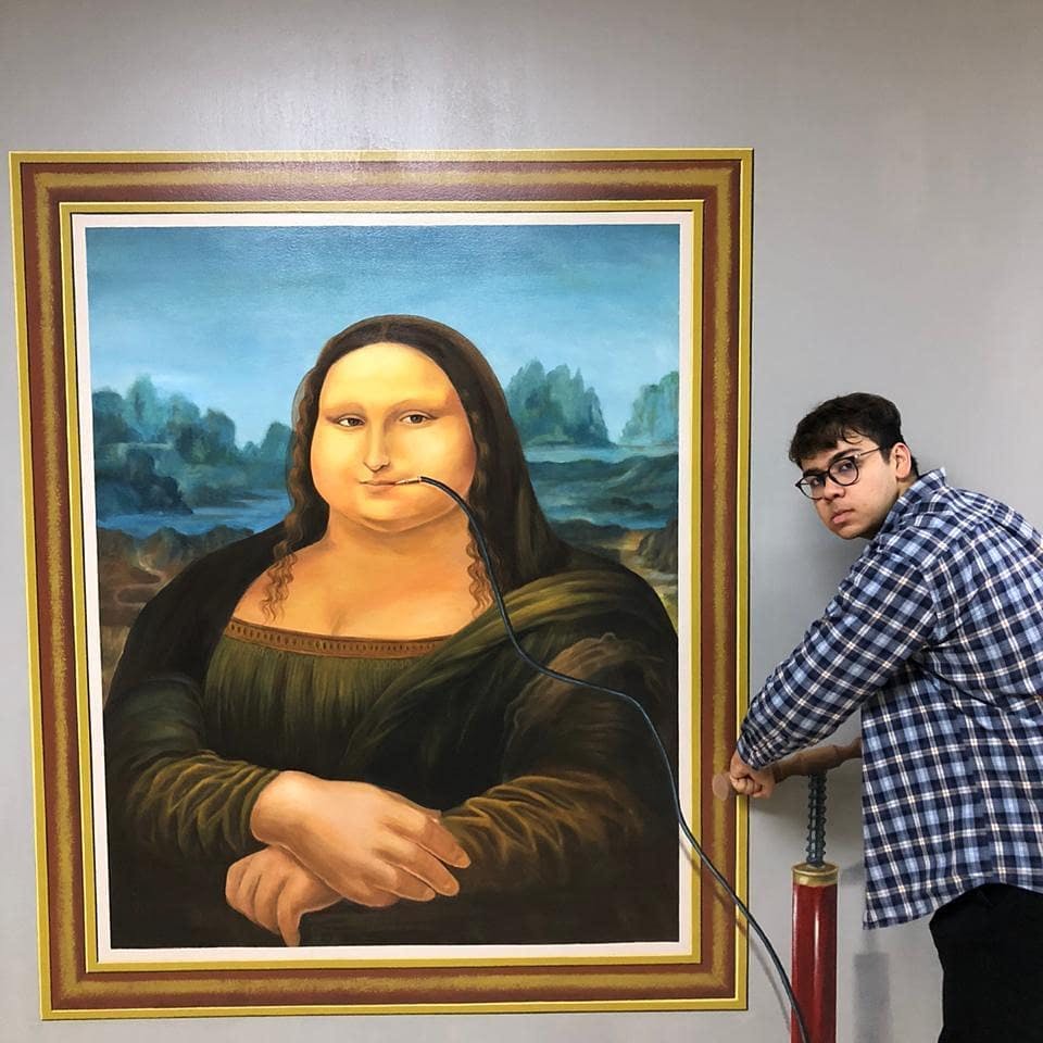 한 사람이 모나리자 그림에 공기를 주입하여 얼굴이 유머러스하게 부풀어오르게 합니다.