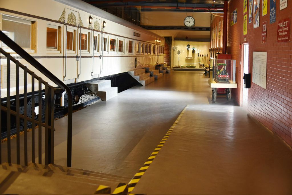 왼쪽에는 빈티지 열차, 오른쪽에는 다양한 유물이 전시되어 있는 조명이 좋은 전시 공간이 있는 실내 전시관입니다.