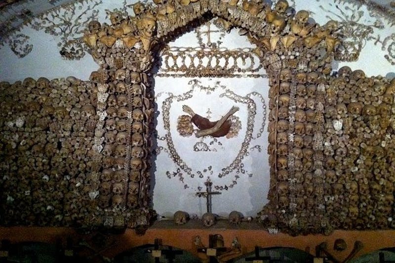 수많은 사람의 두개골과 뼈로 장식된 제단으로, 아치와 문양으로 배열되어 있으며 중앙에는 십자가가 있습니다.