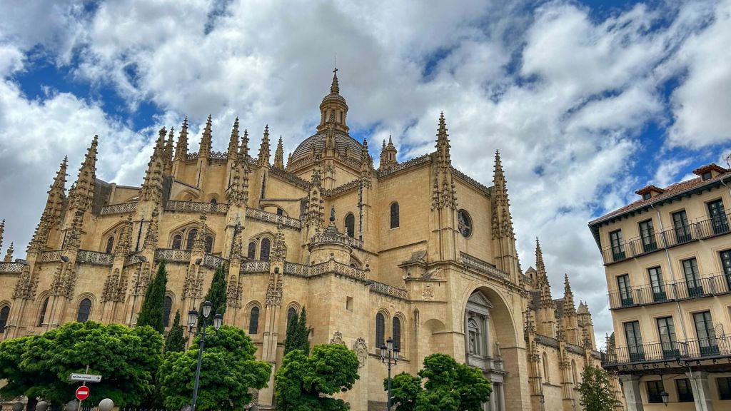 첨탑과 커다란 돔이 있는 고딕 양식의 성당으로, 부분적으로 흐린 하늘을 배경으로 푸른 나무로 둘러싸여 있습니다.